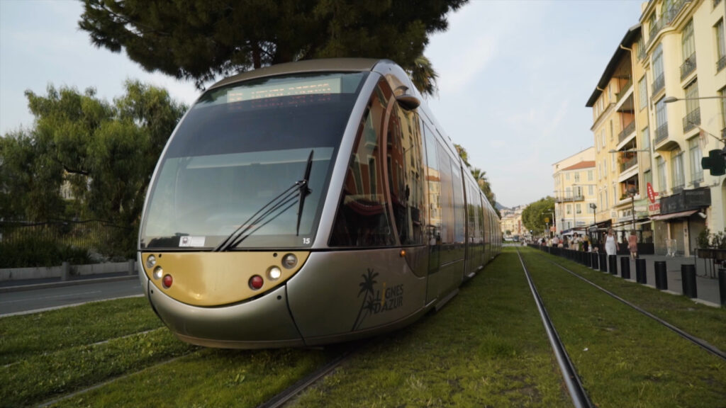 France, Paris - June, 2019: Modern trams riding along rails. Action. Modern stylish models of trams do not need wires. New trams ride on rails of european city with walking tourists.